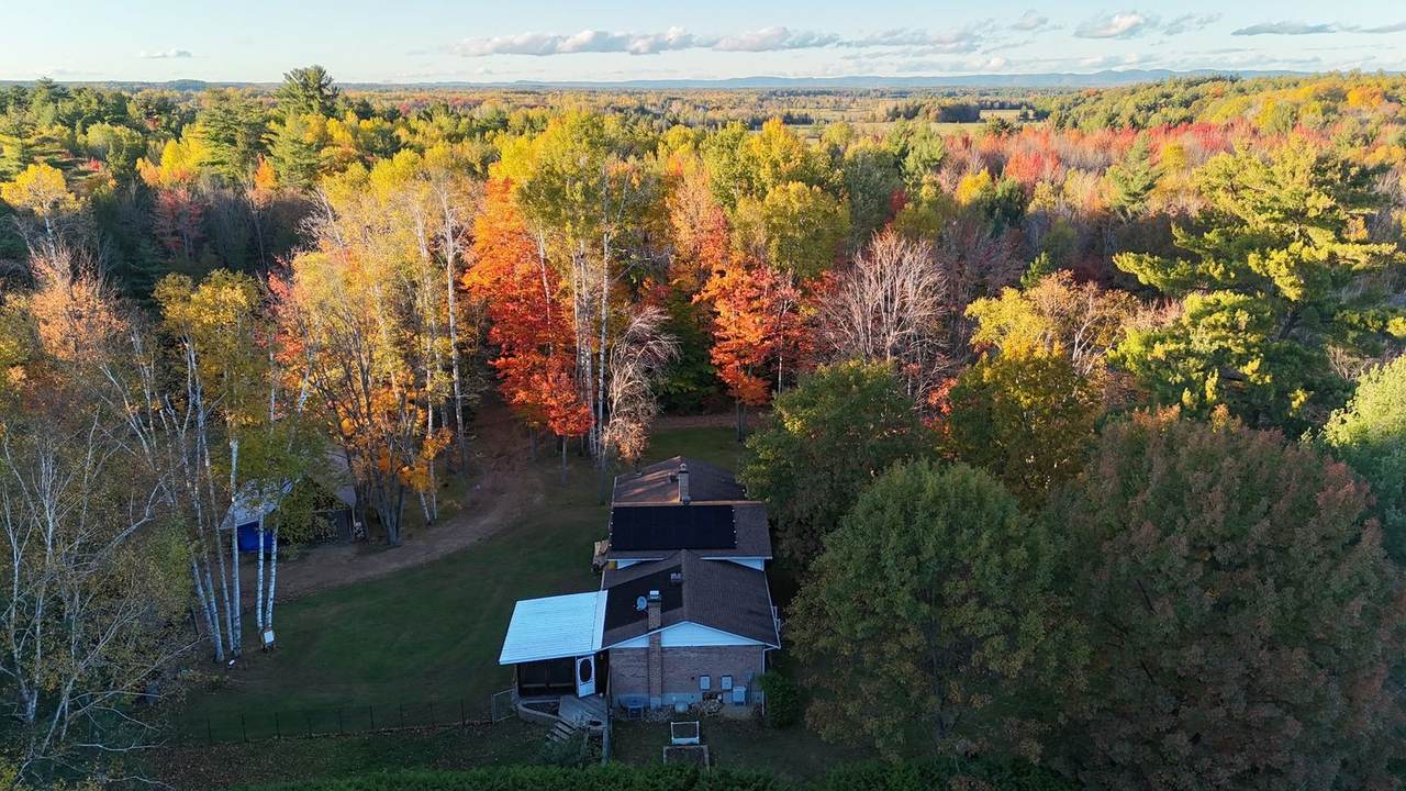 Drone view of a Ronahi solar install on a home surrounded by fall colours